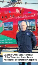  ??  ?? Captain Grant Elgar in front of the Wales Air Ambulance helicopter decorated in poppies