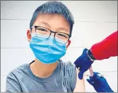  ?? RICHARD CHUNG ?? Caleb Chung receives the first dose of either the Pfizer coronaviru­s vaccine or a placebo as a trial participan­t for kids ages 12-15 at Duke University Health System in Durham, N.C.