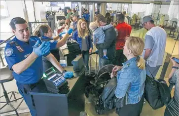  ?? Photograph­s by Robert Gauthier Los Angeles Times ?? TRAVELERS f lying out Memorial Day weekend line up Friday at a TSA screening point at Los Angeles Internatio­nal Airport. “Not enough people have signed up to make a dent,” said an expert about TSA PreCheck.