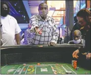  ??  ?? Marlin Guy throws dice Tuesday at the craps table after a grand opening at the Saracen Casino in Pine Bluff. The casino’s 80,000-square-foot gaming floor contains 2,000 slot machines, 35 table games, Sportsbook, a Poker Room and multiple food and beverage options. (Arkansas Democrat-Gazette/Stephen Swofford)