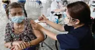  ??  ?? A woman is inoculated with China’s Sinovac COVID-19 vaccine in Quezon, Philippine­s, on Friday. China has sent millions of doses around the world.