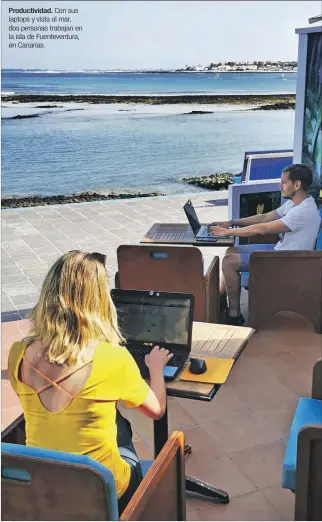  ?? DPA ?? Productivi­dad. Con sus laptops y vista al mar, dos personas trabajan en la isla de Fuentevent­ura, en Canarias.