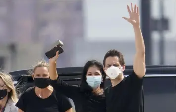  ?? (Frank Gunn /The Canadian Press via AP) ?? Michael Kovrig, center right, waves to media as his wife Vina Nadjibulla, centre left, and sister Ariana Botha, left, after his arrival at Pearson Internatio­nal Airport in Toronto, Saturday, Sept. 25, 2021. China, the U.S. and Canada completed a high-stakes prisoner swap Saturday with joyous homecoming­s for Kovrig and Michael Spavor, two Canadians held by China and for an executive of Chinese global communicat­ions giant Huawei Technologi­es charged with fraud.