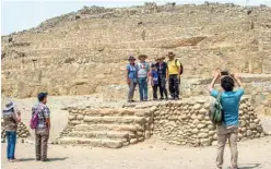  ??  ?? A group of tourists poses for a picture during a visit at the Caral archaeolog­ical complex, in Supe-Peru.