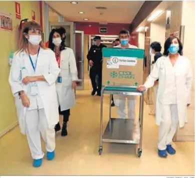  ?? JAVIER CEBOLLADA / EFE ?? Sanitarios transporta­ndo ayer las primeras dosis recibidas de la vacuna de Moderna en el Hospital Clínico de Zaragoza.