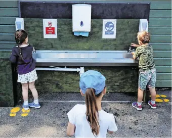  ??  ?? Children wash their hands at a school in Britain after they reopened there. School principals here are concerned about the cost of measures that will need to be introduced to combat Covid-19.