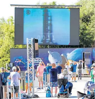  ?? JOE BURBANK/ORLANDO SENTINEL ?? Guests watch the countdown Tuesday during the Apollo 11 Launch Flashback broadcast by CBS at the Kennedy Space Center's Apollo/Saturn V exhibit.