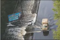  ?? The Associated Press ?? WASHED AWAY: A National Guard vehicle drives past a truck washed off the roadway from floodwater­s in Dillon, S.C., Monday in the aftermath of Hurricane Florence.