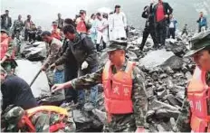  ?? AFP ?? Chinese military police and rescue workers are seen at the site of a landslide in Xinmo village, Diexi town, Maoxian county, Sichuan Province, yesterday.