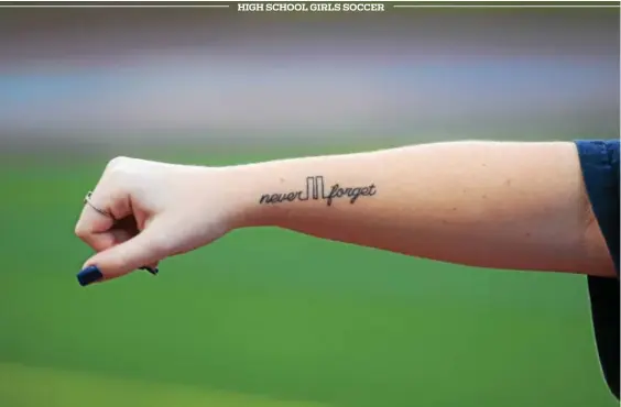  ?? AUSTIN HERTZOG — DIGITAL FIRST MEDIA ?? Daniel Boone alum Taylor Carroll displays her ‘never forget’ tattoo on Sept. 11 ahead of the Blazers’ girls soccer game with Exeter. The Daniel Boone team has annually held a Sept. 11 tribute that was started by the Carroll family, whose father was a...