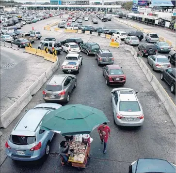  ?? GUILLERMO ARIAS AFP/Getty Images ?? VEHICLES on the Tijuana side of the border wait — and wait — to eventually cross in to the United States.