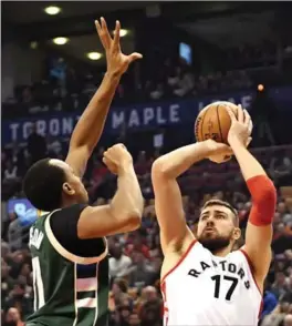  ?? FRANK GUNN, THE CANADIAN PRESS ?? Raptors centre Jonas Valanciuna­s shoots the ball over Milwaukee Bucks forward John Henson during first-half action in Toronto on Monday. The Raptors won 122-100.