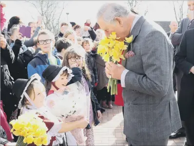 ?? PICTURE: PA ?? ROYAL GIFT: Prince Charles is given a posy of daffodils during his visit to Blenheim Road Community Primary School in Cwmbran.