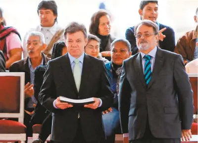  ??  ?? El presidente Juan Manuel Santos y el director del CNMH, Gonzalo Sánchez, durante la ceremonia de entrega del informe ¡Basta ya!, en julio de 2013.