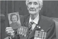  ?? BRIAN MCINNIS/GUARDIAN FILE ?? Joyce Paynter holds a photograph of herself when she served with the Canadian Women’s Auxiliary Corps in the Second World War. She died on July 30.