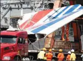  ?? ?? Workers unload debris, belonging to the crashed Air France flight AF447, from the Brazilian Navy’s Constituti­on Frigate in the port of Recife, northeast of Brazil, June 14, 2009. It was the worst plane crash in Air France history, killing people of 33 nationalit­ies and having lasting impact. It led to changes in air safety regulation­s, how pilots are trained and the use of airspeed sensors. (AP)