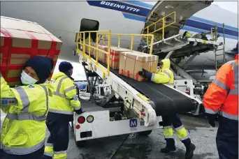  ?? RICHARD VOGEL — THE ASSOCIATED PRESS FILE ?? In this April 10, 2020, file photo, wearing protective masks ground crew at the Los Angeles Internatio­nal airport unload supplies of medical personal protective equipment, PPE, from a China Southern Cargo plane upon it’s arrival.