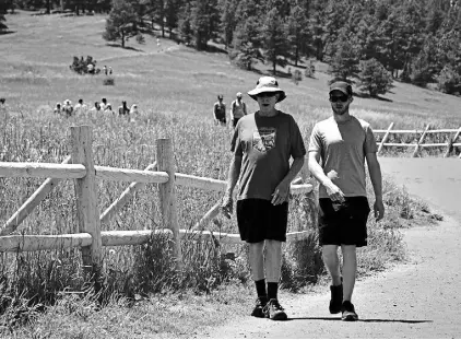  ?? Kelsey Hammon, Longmont Times-call ?? Steven Gardner, left, and his son, Matt Gardner, hike in Chautauqua Park earlier this month. The father and son duo were among many visitors at the popular park, but they said the crowds didn’t bother them.