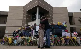  ??  ?? People embrace at the police station in front of a memorial for Eric Talley on 24 March in Boulder, Colorado. Photograph: Paula Bronstein./Getty Images