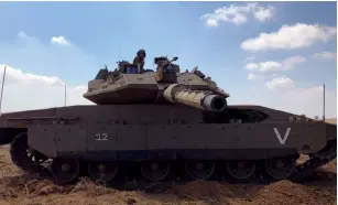  ?? (Anna Ahronheim) ?? AN IDF SOLDIER sits atop a Merkava tank during a drill in the North.