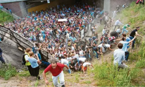  ?? Foto: Erik Wiffers, dpa ?? Tausende drängen sich 2010 auf der Loveparade in und vor einem Tunnel in Duisburg, in dem es damals zu einer Massenpani­k kommt.