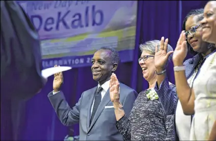  ?? HYOSUB SHIN / HSHIN@AJC.COM ?? DeKalb County CEO Mike Thurmond (left) and other county officials are sworn in as Judge Clarence Seeliger (foreground) administer­s oaths of office during the honorary swearing-in ceremony and reception at Manuel Maloof Auditorium on Friday.