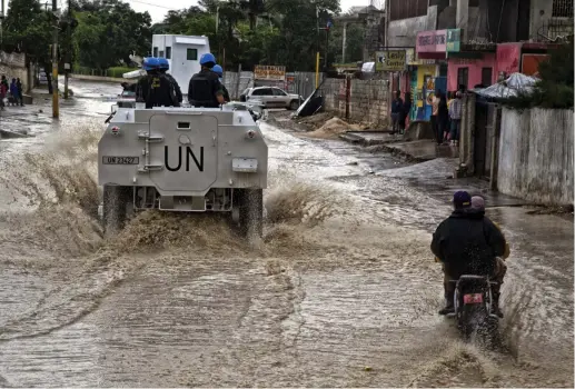  ?? (Igor Rugwiza/TNS) ?? BRAZILIAN PEACEKEEPE­RS with the UN Force Commander conduct a patrol in downtown Port au Prince last October in the wake of Hurricane Matthew.