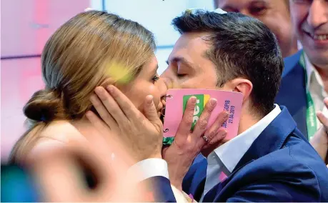  ??  ?? Con la moglie Il comico Volodymyr Zelensky bacia la moglie Olena dopo l’annuncio dei risultati (Afp/ Sergei Gapon)