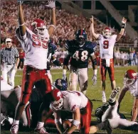  ?? NWA Democrat-Gazette/J.T. WAMPLER ?? Marcellus Poydras (95) and Matt Jones (9) of the University of Arkansas react to a Mark Pierce score during the Hogs’ 58-56, seven-overtime victory against Ole Miss on Nov. 3, 2001, at Vaught-Hemingway Stadium in Oxford, Miss. A new NCAA rule will change how games are handled once a fifth overtime is reached.