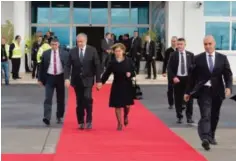  ?? —AFP ?? CYPRUS: A handout picture released by the Presidency of the self-proclaimed Turkish Republic of Northern Cyprus (KKTCB), shows Turkish Cypriot leader Mustafa Akinci (C-L) and his spouse walk down the red carpet at Ercan Airport in the self-proclaimed...