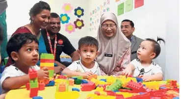  ??  ?? Family outing: Dr Wan Azizah chatting with the children during her visit to Krista@RedQ. Also present are (from left) Fernandes, principal Rajeswary Jesslyn (left) and other officials.