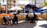  ?? AP-Marcio Jose Sanchez ?? Diners eat lunch outside at Settebello Pizzeria Napoletana on Tuesday in Pasadena, Calif. Pasadena has become an island in the center of the nation’s most populous county, where a surge of COVID-19 cases last week led to a threeweek end to outdoor dining and California’s first stay-home order since the pandemic began to spread across the state in March. The decision by Pasadena health authoritie­s to buck Los Angeles County has been a relief to restaurate­urs.