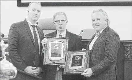  ?? JULIE JOCSAK THE ST. CATHARINES STANDARD ?? Rod Mawhood, left, presents the 2017 St. Catharines sportspers­ons of the year awards to Doug Geddie and Keith Shaver at a ceremony Monday night in council chambers at city hall.
