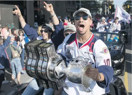  ?? DAX MELMER ?? Jeremiah Addison yells to the crowd as he hoists the Memorial Cup during the Windsor Spitfires’ victory parade in downtown Windsor on Wednesday. Also in the car with Addison are Jalen Chatfield, left, and Cristiano DiGiacinto.