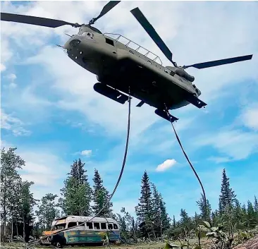  ?? AP ?? The Alaska Army National Guard uses a CH-47 Chinook helicopter to remove the abandoned bus popularise­d by the book and movie
,toan undisclose­d location.