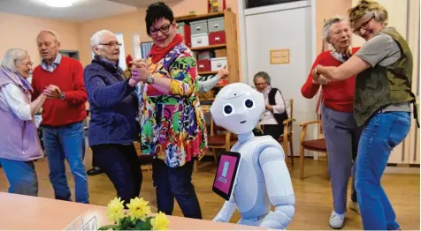  ?? Foto: Carsten Rehder, dpa ?? Roboter „Emma“spielt in einer Demenz Wohngruppe der Diakonie Altholstei­n in Kiel Musik zum Tanz. Alle zwei Wochen bringt der Roboter Schwung in die Wohngruppe. Der Roboter spricht, spielt auf Wunsch Musik und macht bei Bedarf sogar Fotos von den...