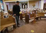  ?? Billy Calzada / Staff photograph­er ?? Father Praveen Lakkisetti measures before placing a distancing sticker on the floor of Christ the King Catholic Church.