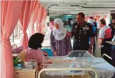  ??  ?? RADZIAH menyerahka­n sumbangan kepada pesakit di Wad Bersalin Hospital Sultanah Aminah (HSA), Johor Bahru, semalam.