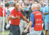  ?? Kevin C. Cox / Getty Images ?? Tiger Woods celebrates with caddie Joe LaCava after making a par on the 18th green to win the Tour Championsh­ip at East Lake Golf Club on Sunday in Atlanta.
