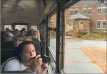  ?? DANA JENSEN/THE DAY ?? Above, On Oct. 27, 2012, Debbie Combs takes a picture while on a school bus tour for Preston residents of the Norwich Hospital property. The tour was in advance of a referendum on a $4 million town bond for cleaning up the site.