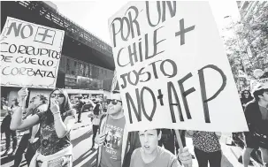 ?? — Gambar AFP ?? RIUH: Ribuan pekerja berarak untuk membantah sistem pencen Chile yang diswastaka­n di bawah pemerintah­an diktator Pinochet, di Santiago kelmarin.