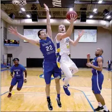  ?? Photo courtesy of JBU Sports Informatio­n ?? John Brown sophomore guard Jake Caudle goes to the basket as Southweste­rn Christian’s Casey Cole defends during Thursday’s basketball game at Bill George Arena. Southweste­rn Christian defeated the Golden Eagles 77-65.