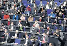  ?? MARKUS SCHREIBER — THE ASSOCIATED PRESS ?? Lawmakers wear face mask as they attend a parliament Bundestag session about new measures to battle the coronaviru­s pandemic at the Reichstag building in Berlin, Germany, on Thursday.