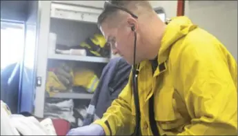  ?? IMPERIAL VALLEY PRESS FILE PHOTO ?? Calexico firefighte­r/paramedic Wes Knowlton tends to a patient in an ambulance during a medical call July 2011.