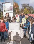  ??  ?? Thomas Geisel füllt mit den Schülern den Grundstein.