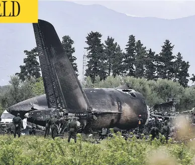  ?? RYAD KRAMDI / AFP / GETTY IMAGES ?? Rescuers work around the wreckage of an Algerian army plane that crashed after taking off near the Boufarik airbase on Wednesday. Officials say 257 people were killed, mostly army personnel and members of their families.