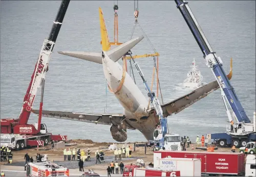  ??  ?? Turkish authoritie­s used cranes to haul the Pegasus Airlines Boeing 737-800 from the cliff at Trabzon airport.