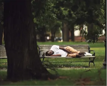  ?? Brian A. Pounds / Hearst Connecticu­t Media ?? A man sleeps on a bench on the Green in New Haven. At right, formerly homeless but currently housed in an apartment, Marta Lopez of New Haven hangs out on the Green in New Haven. Lopez said she has struggled to find a job during the COVID-19 pandemic. Below, a homeless person’s sleeping setup on the Green.