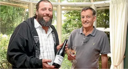  ?? PHOTO: DEREK FLYNN/FAIRFAX NZ ?? Mashgiach Eric Anderson, left, and O’Dwyers Creek Vineyard owner Lindsay Dahlberg with a bottle of kosher wine.