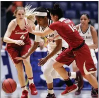  ?? AP/MARK HUMPHREY ?? Texas A&M guard Jada Walton (center) tries to get past Arkansas defenders Keiryn Swenson (4) and Jailyn Mason (14) in the second half of a second-round SEC Tournament game Thursday in Nashville, Tenn. Fifth-seeded Texas A&M won 82-52 to advance to play...